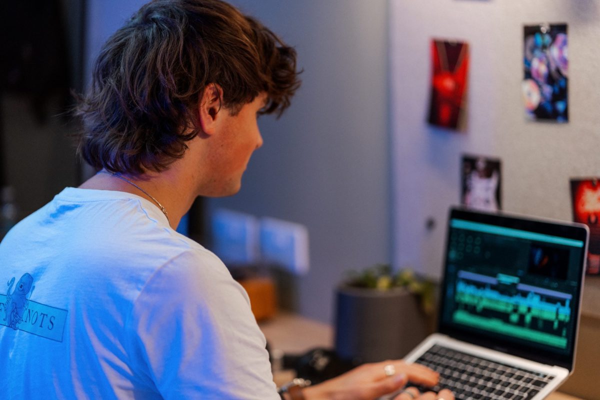 male student working on laptop in room