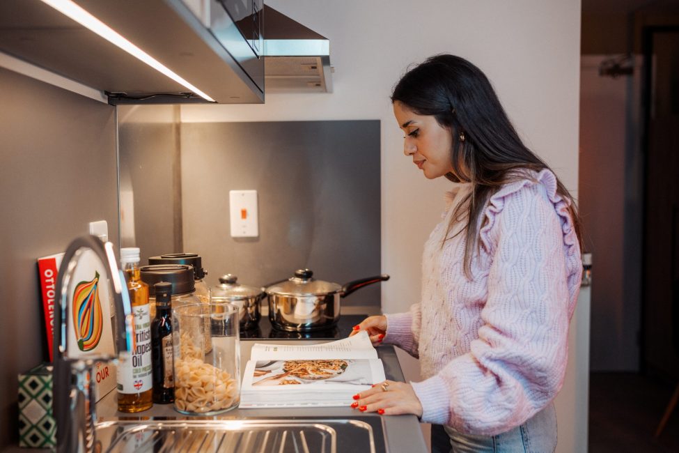 Student in her flat cooking meal