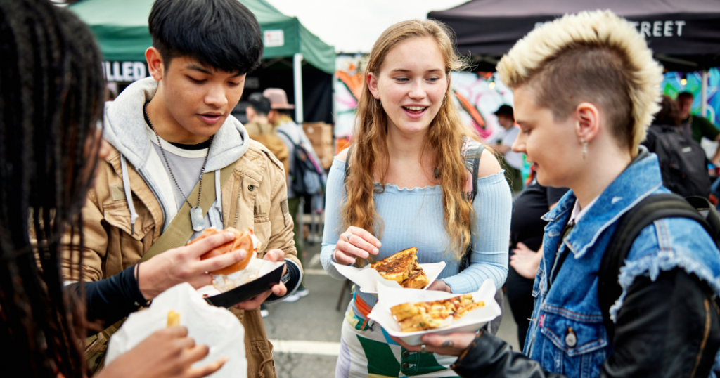 friends eating street food in london