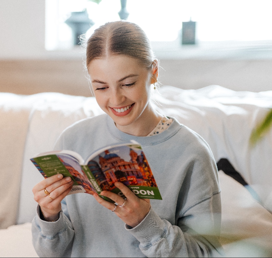 Student reading book about London whilst sat on a bed